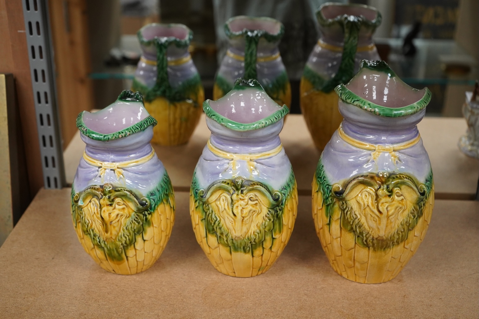 A graduated set of three maiolica ram decorated jugs, tallest 23cm high.